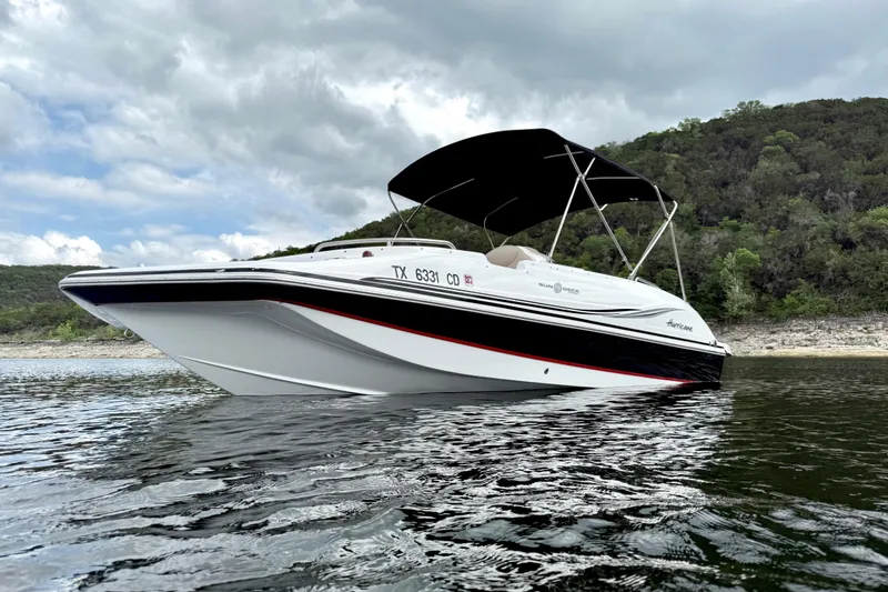Slide: The Image of 2014 Hurricane SunDeck Sport 202 IO boat on water, under cloudy sky. - 3