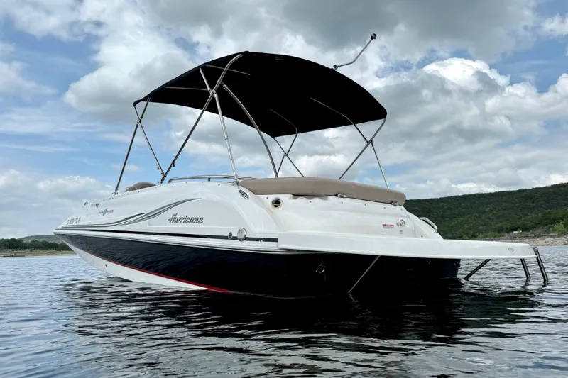 Slide: The Image of 2014 Hurricane SunDeck Sport 202 IO boat on calm water under cloudy sky. - 4