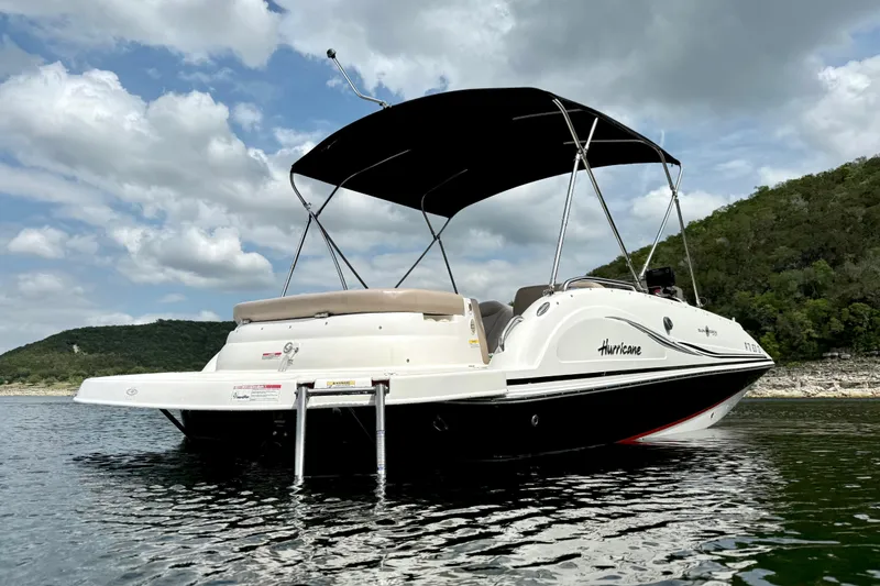 Slide: The Image of 2014 Hurricane SunDeck Sport 202 IO boat on a lake with scenic background. - 6