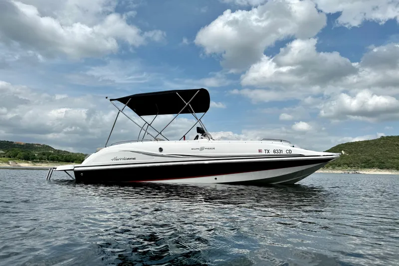 Slide: The Image of 2014 Hurricane SunDeck Sport 202 IO boat on calm water under cloudy sky. - 7