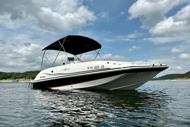 Slide: The Image of 2014 Hurricane SunDeck Sport 202 IO boat on calm water under cloudy sky. - 8