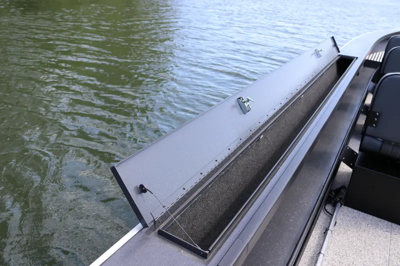 Slide: The Image of 2026 Alumaweld Pacific CC 26 boat with open storage compartment on calm water. - 27