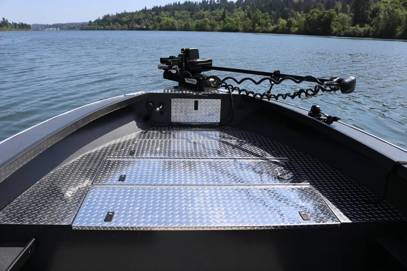 Slide: The Image of 2026 Alumaweld Pacific CC 26 boat deck with diamond plate flooring on a scenic lake. - 20