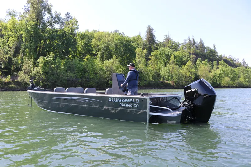 Slide: The Image of 2026 Alumaweld Pacific CC 26 boat on a scenic lake with lush green trees. - 4