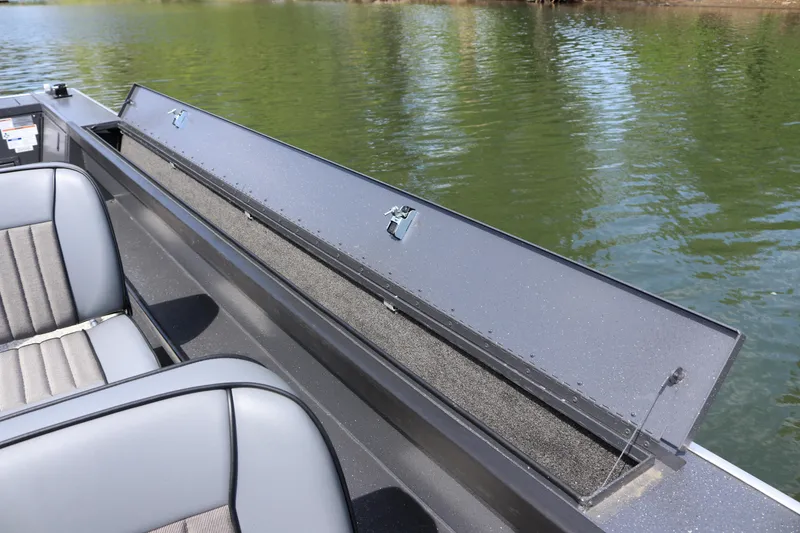 Slide: The Image of 2026 Alumaweld Pacific CC 26 boat interior with open storage compartment on calm water. - 25