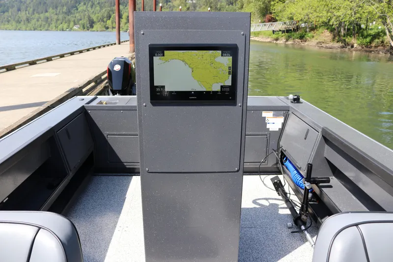 Slide: The Image of 2026 Alumaweld Pacific CC 26 boat interior with navigation display, docked by a scenic river. - 10
