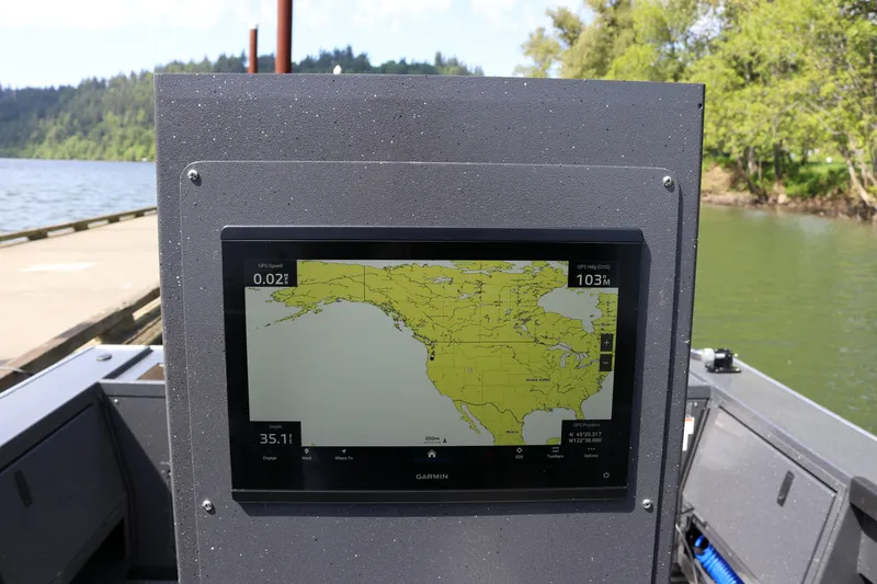 Slide: The Image of Garmin navigation display on 2026 Alumaweld Pacific CC 26 boat, near scenic lake. - 26