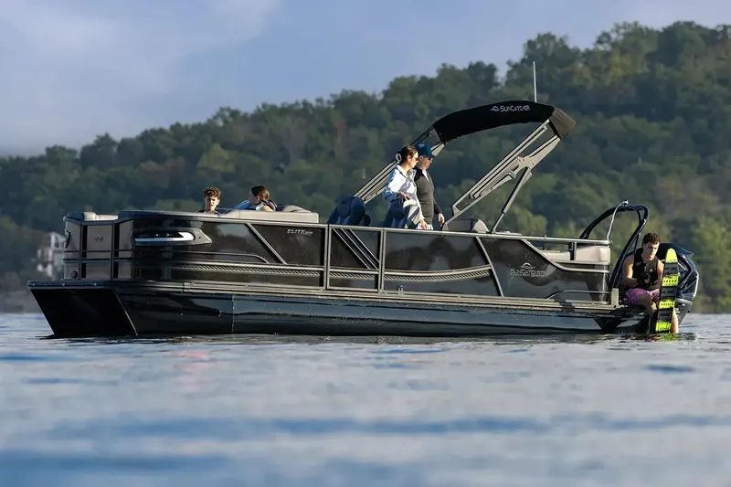 Slide: The Image of Manufacturer Provided Image: 2026 SunCatcher Elite 324 SS pontoon boat on a lake with people enjoying water activities. - 16