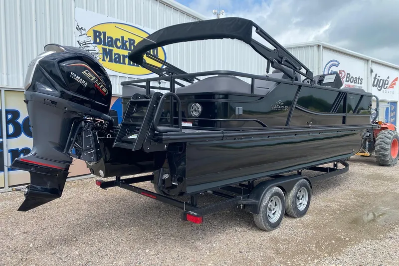 Slide: The Image of 2026 SunCatcher Elite 324 SS boat on trailer, featuring Yamaha engine, parked outside dealership. - 5