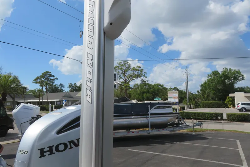 Slide: The Image of 2014 Avalon Catalina Fish 24' pontoon boat on trailer, sunny day, parking lot. - 12