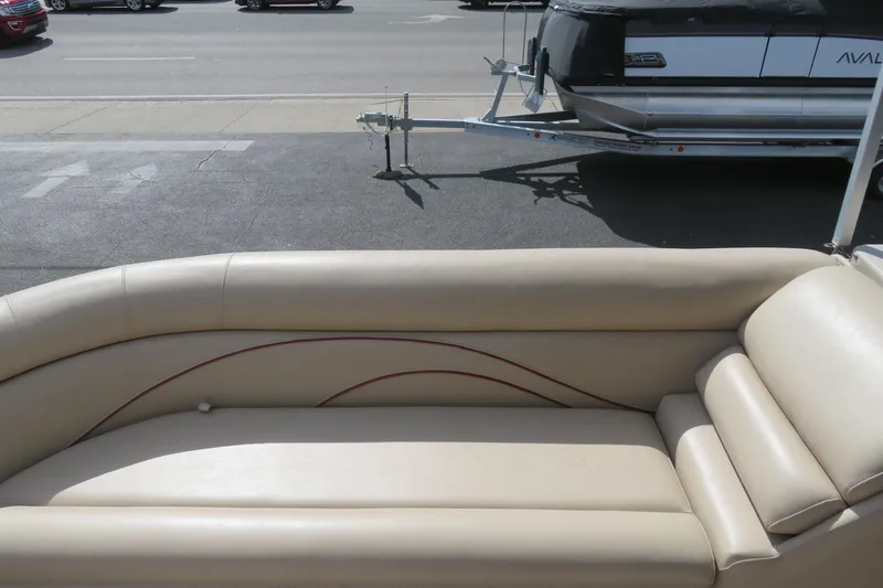 Slide: The Image of 2014 Avalon Catalina Fish 24' boat with beige seating and trailer in background. - 14