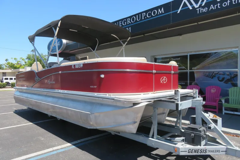 Slide: The Image of 2014 Avalon Catalina Fish 24' pontoon boat on trailer, parked outside dealership. - 4