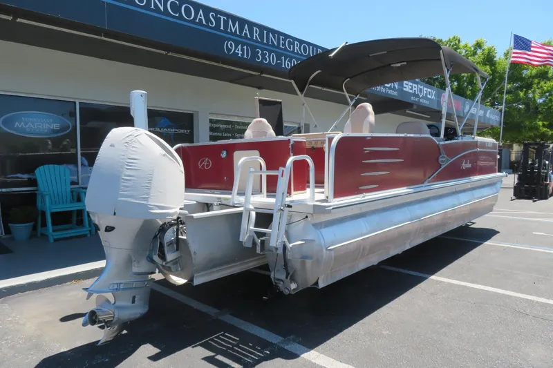 Slide: The Image of 2014 Avalon Catalina Fish 24' pontoon boat with covered motor, parked outside dealership. - 6