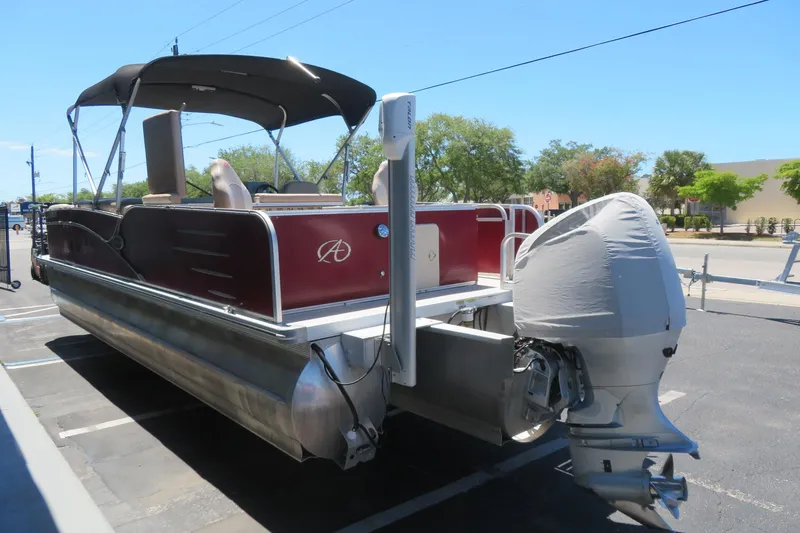 Slide: The Image of 2014 Avalon Catalina Fish 24' pontoon boat with covered outboard motor in parking lot. - 8