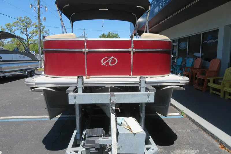 Slide: The Image of 2014 Avalon Catalina Fish 24' pontoon boat on trailer, red exterior, parked outside dealership. - 9