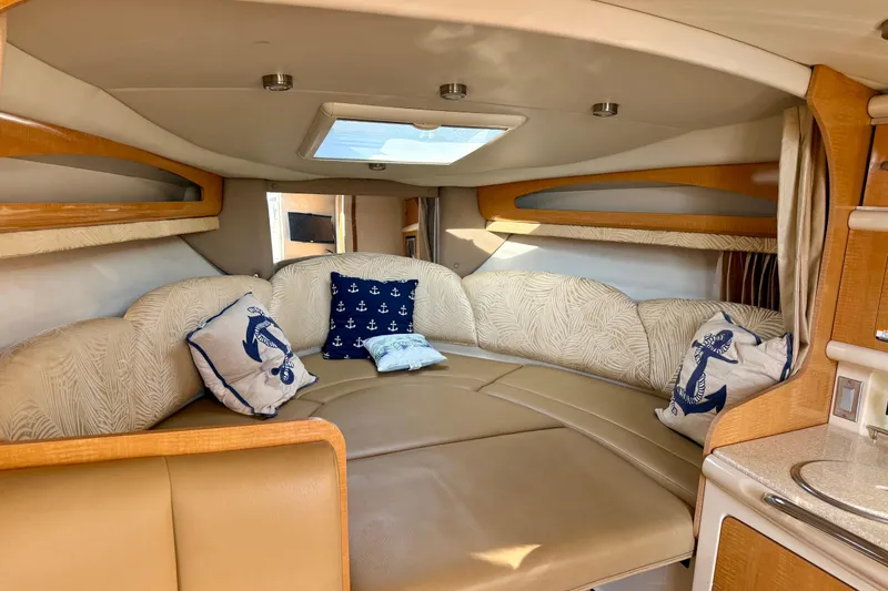 Slide: The Image of 2006 Chaparral Signature 290 cabin interior with cozy seating and nautical-themed pillows. - 12