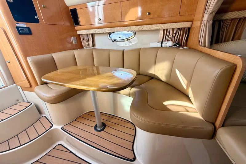Slide: The Image of Interior of 2006 Chaparral Signature 290 boat with beige seating and wooden table. - 16