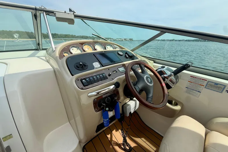 Slide: The Image of 2006 Chaparral Signature 290 boat cockpit with steering wheel and control panel on open water. - 22