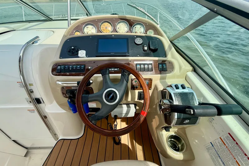 Slide: The Image of 2006 Chaparral Signature 290 helm with wooden steering wheel and modern controls on water. - 27