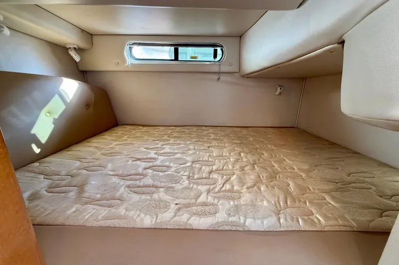 Slide: The Image of 2006 Chaparral Signature 290 cabin interior with a cozy bed and small window. - 28