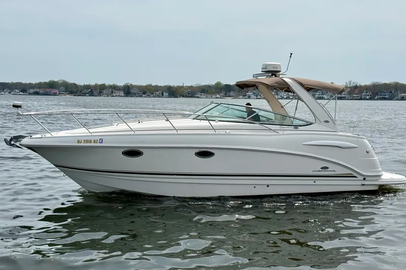 Slide: The Image of 2006 Chaparral Signature 290 boat cruising on a calm lake with scenic shoreline. - 34
