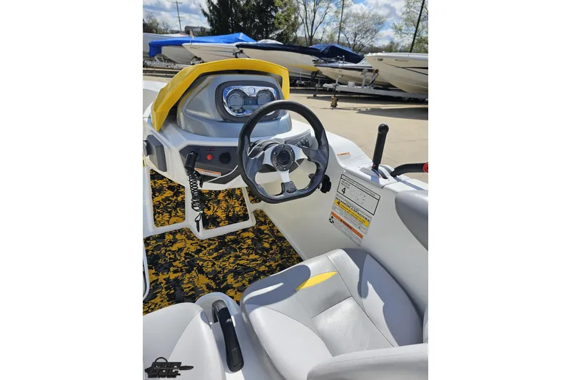 Slide: The Image of 2007 Sea-Doo 150 Speedster cockpit with steering wheel and controls, parked near other boats. - 52
