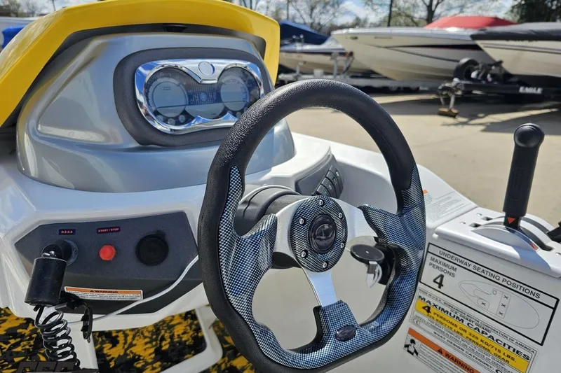 Slide: The Image of 2007 Sea-Doo 150 Speedster dashboard with steering wheel and controls, parked among other boats. - 59