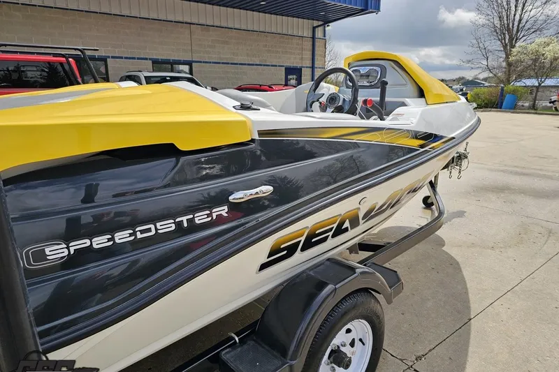 Slide: The Image of 2007 Sea-Doo 150 Speedster boat with yellow accents on a trailer, parked outdoors. - 6