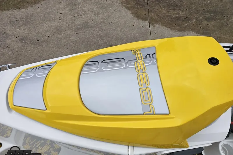 Slide: The Image of 2007 Sea-Doo 150 Speedster boat with yellow and gray design on concrete surface. - 70
