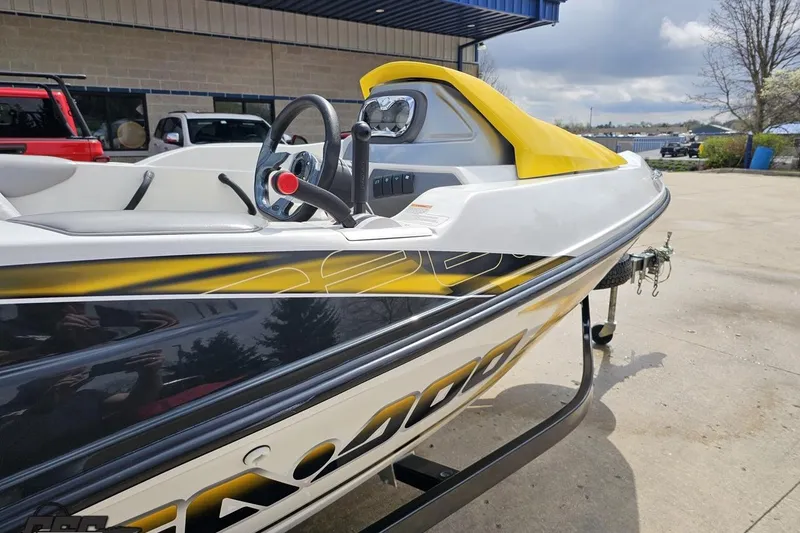 Slide: The Image of 2007 Sea-Doo 150 Speedster boat with yellow accents, parked on a trailer. - 8