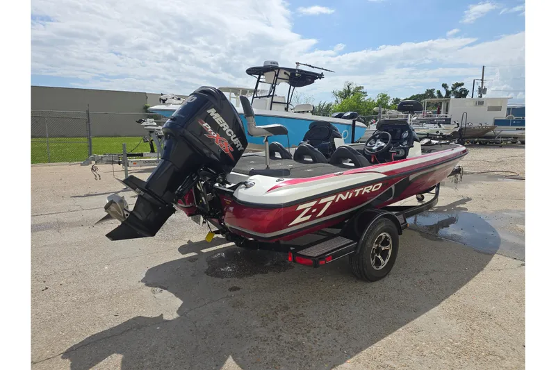 Slide: The Image of 2015 Nitro Z-7 boat with Mercury Pro XS engine, parked outside a garage. - 2
