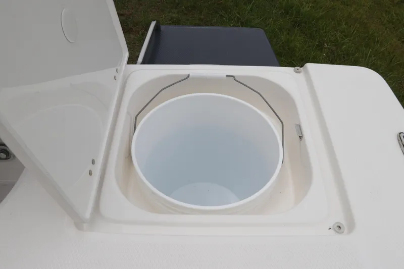 Slide: The Image of Open storage compartment with bucket on 2026 Robalo 206 Cayman boat. - 11