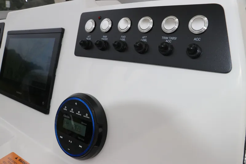 Slide: The Image of Control panel of 2026 Robalo 206 Cayman boat with switches and Clarion audio system. - 21