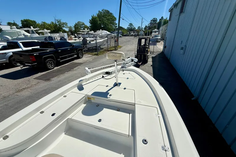 Slide: The Image of 2017 NauticStar 227 XTS boat parked near a warehouse, surrounded by vehicles. - 5