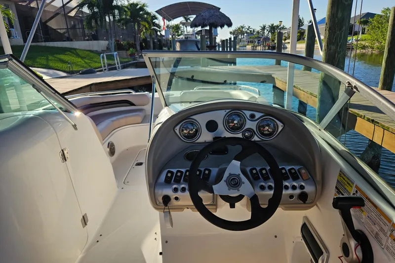 Slide: The Image of 2013 Hurricane SunDeck 217 OB boat interior with steering wheel and dashboard controls. - 7