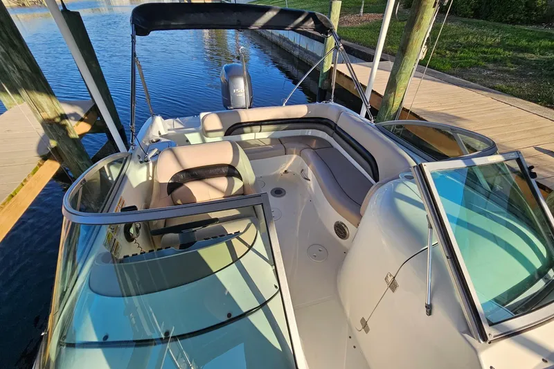 Slide: The Image of 2013 Hurricane SunDeck 217 OB boat docked, featuring spacious seating and sleek design. - 8