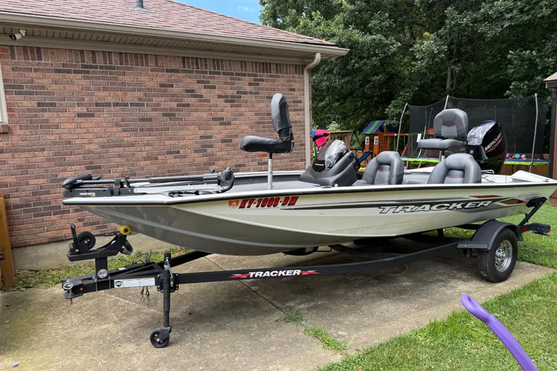 The Image of 2024 Bass Tracker Pro 17 fishing boat on trailer, parked beside a brick house. - 1
