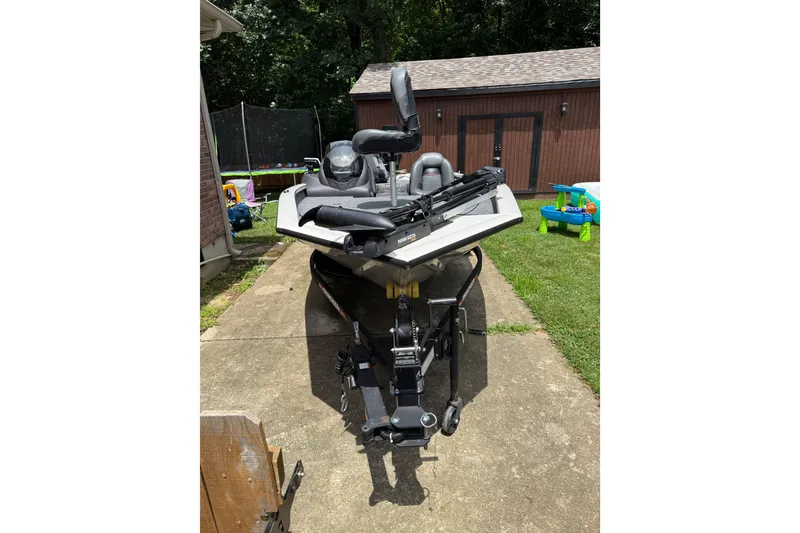 Slide: The Image of 2024 Bass Tracker Pro 17 boat parked on a driveway near a shed. - 11
