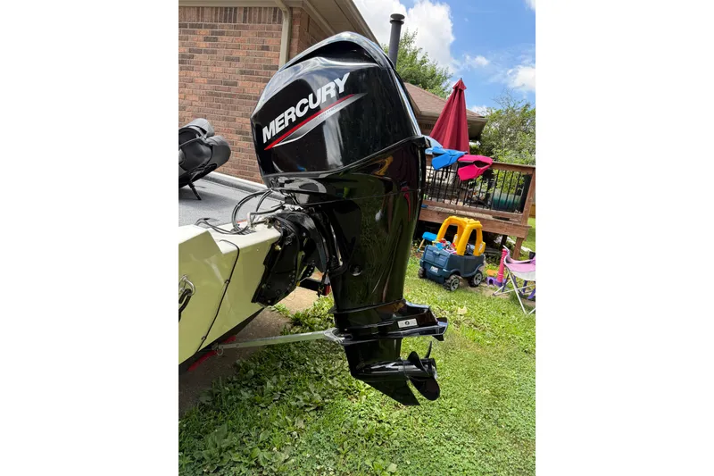 Slide: The Image of 2024 Bass Tracker Pro 17 with Mercury outboard motor in a backyard setting. - 15