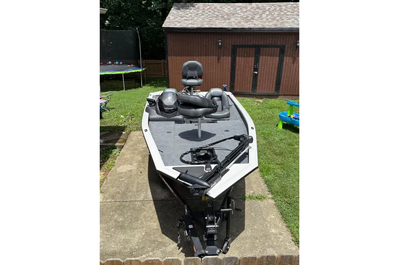 Slide: The Image of 2024 Bass Tracker Pro 17 boat parked outdoors near a wooden shed. - 3