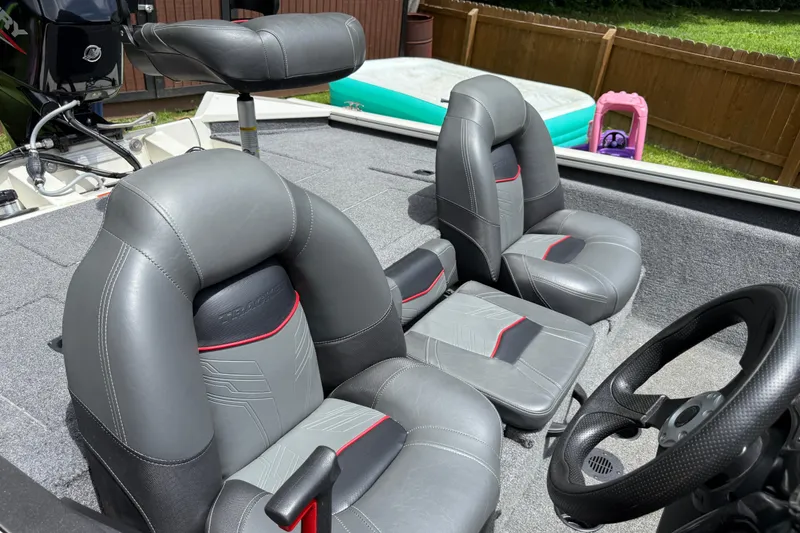 Slide: The Image of 2024 Bass Tracker Pro 17 boat interior with gray seats and steering wheel. - 7