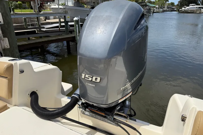 Slide: The Image of 2017 Scout 210 Dorado with Yamaha 150 outboard motor on a calm waterway. - 13