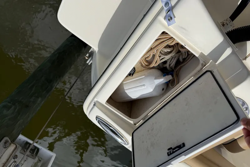 Slide: The Image of Storage compartment on a 2017 Scout 210 Dorado boat with rope and container. - 15