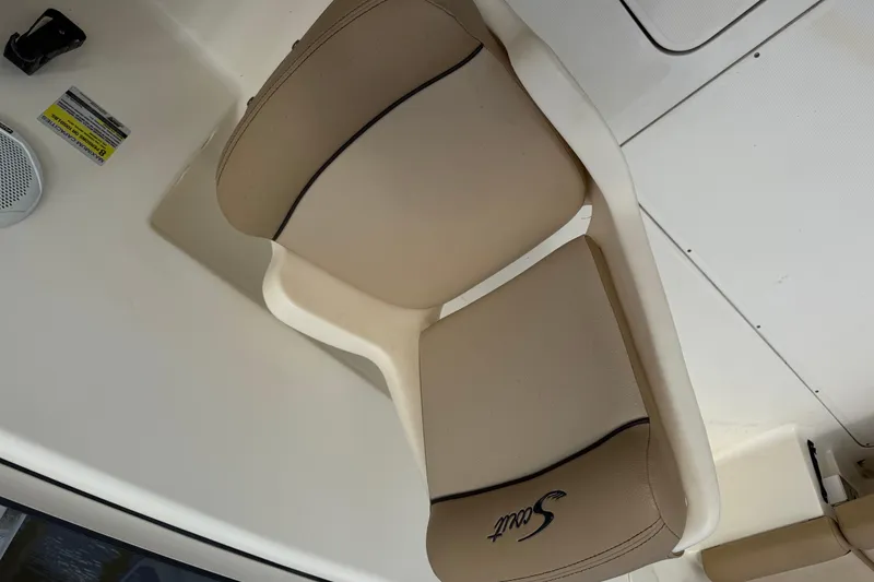 Slide: The Image of Beige seat on 2017 Scout 210 Dorado boat interior, featuring logo and speaker. - 17