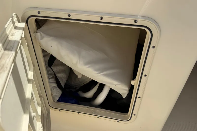 Slide: The Image of Storage compartment on a 2017 Scout 210 Dorado boat with various items inside. - 32