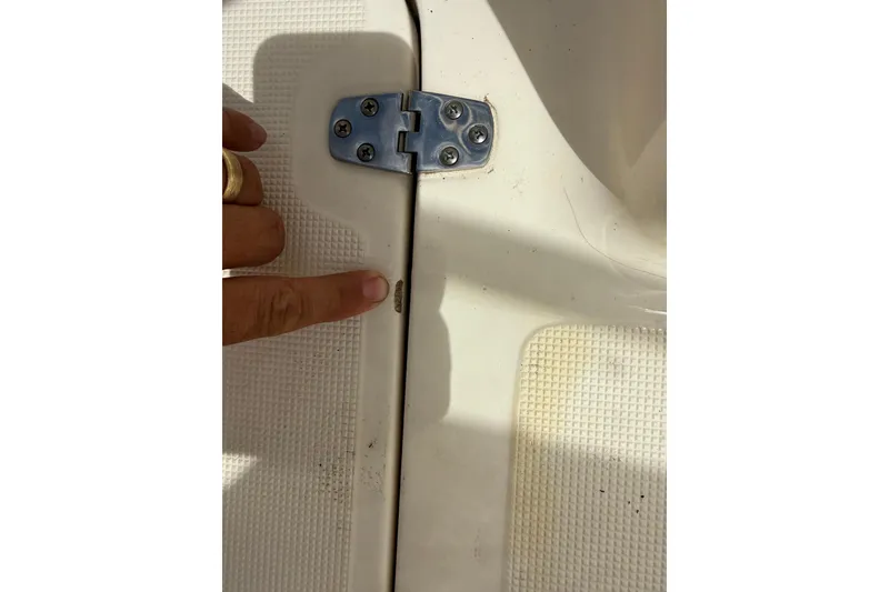 Slide: The Image of Close-up of a 2017 Scout 210 Dorado boat hinge with finger pointing. - 34