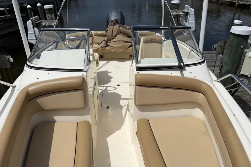 Slide: The Image of 2017 Scout 210 Dorado boat interior with tan seating and dual windshields at dock. - 37