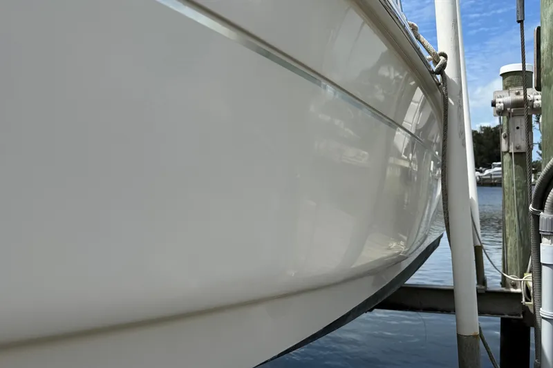 Slide: The Image of 2017 Scout 210 Dorado boat hull reflecting sunlight at a marina dock. - 4