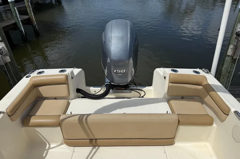 Slide: The Image of 2017 Scout 210 Dorado boat with 150 HP engine, docked by the water. - 6