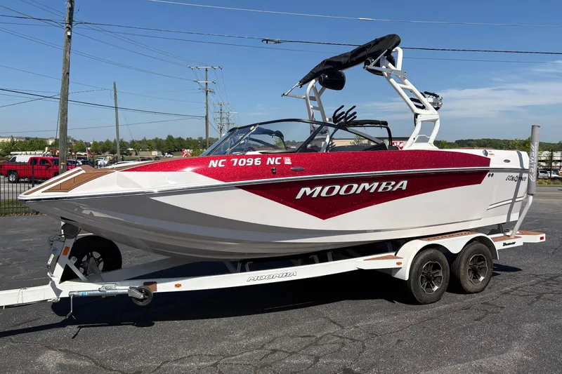 The Image of 2023 Moomba Kaiyen boat on trailer, red and white design, parked outdoors. - 0